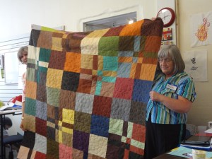 Modern quilt pieced with solids and quilted with a modern pebble design.